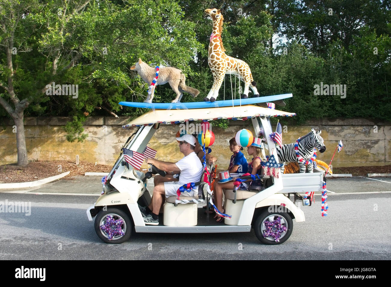 Sullivans Island, South Carolina, USA. 4. Juli 2017. Eine Familie fährt mit in einem Golfwagen, dekoriert mit ausgestopften Tieren während der jährlichen Sullivan Island Independence Day Parade 4. Juli 2017 in Sullivans Island, South Carolina. Die winzigen wohlhabenden Meer Insel beherbergt eine Fahrrad- und Golf Cart-Parade durch das historische Dorf. Bildnachweis: Planetpix/Alamy Live-Nachrichten Stockfoto