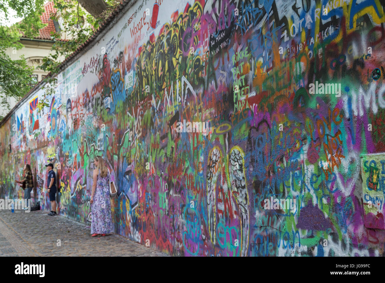 Nur wenige Touristen und ein Straßenmusikant an der John-Lennon-Mauer in Prag. Es ist eine Wand mit Stücken von songtexte von Beatles Songs und John Lennon inspirierten Graffiti. Stockfoto