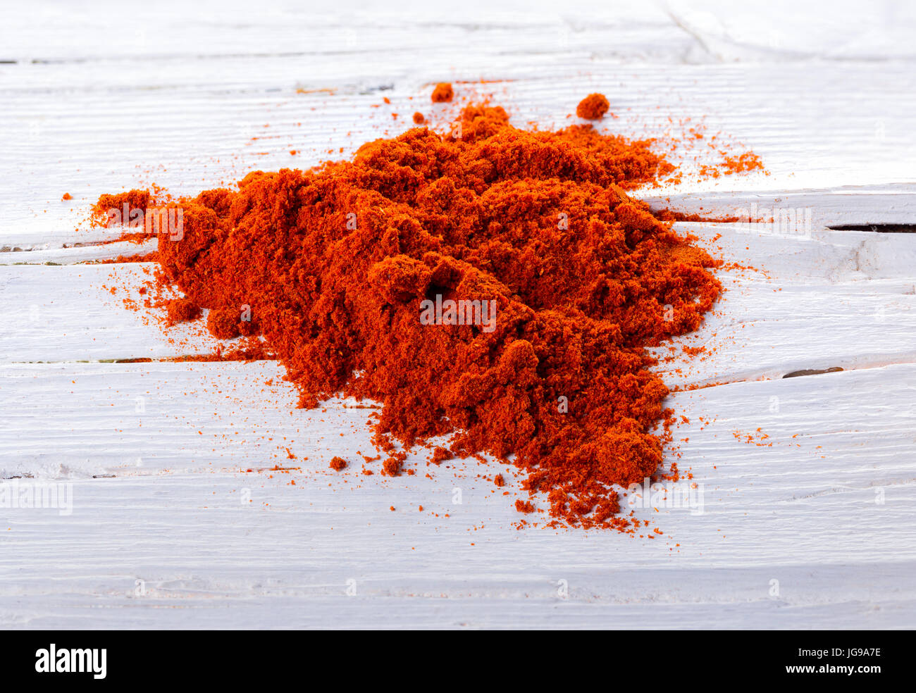 Haufen von Paprika Schwitzen Paprikapulver auf weißem Hintergrund aus Holz. Stockfoto