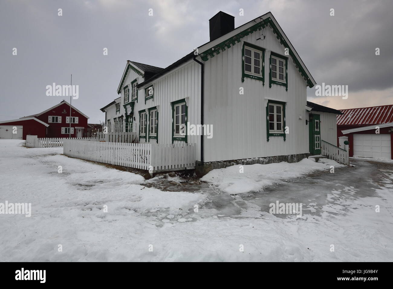 Häuser aus Holz weiß lackiert mit grünen Fenster-Türen und rot mit weißen Fenster-Türen mit angehängten Schuppen Gehäuse der Garagen. Nordmela-Andøya Insel- Stockfoto