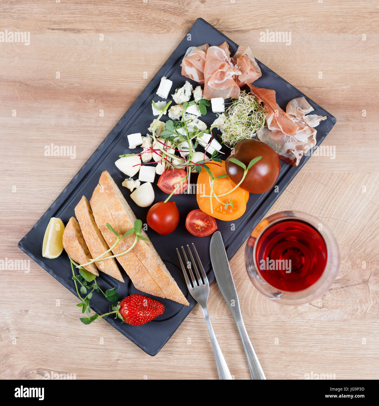 Snacks auf schwarzem Schiefer an Bord über hölzerne Hintergrund. Zartheit und einfaches Essen. Stockfoto