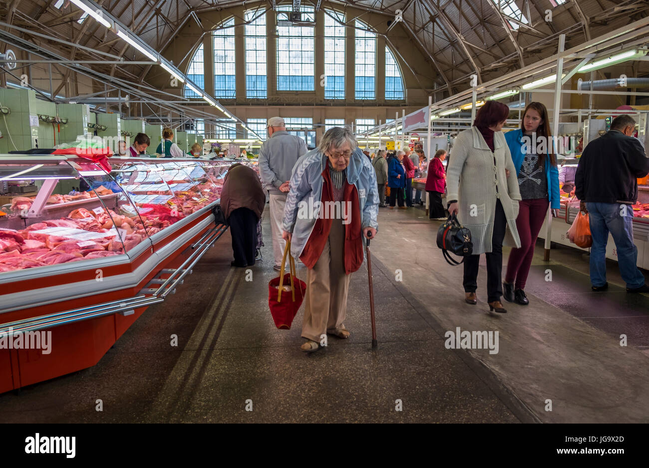 RIGA, Lettland - ca. Mai 2014: alte Frau zu Fuß im Rigaer Zentralmarkt Stockfoto