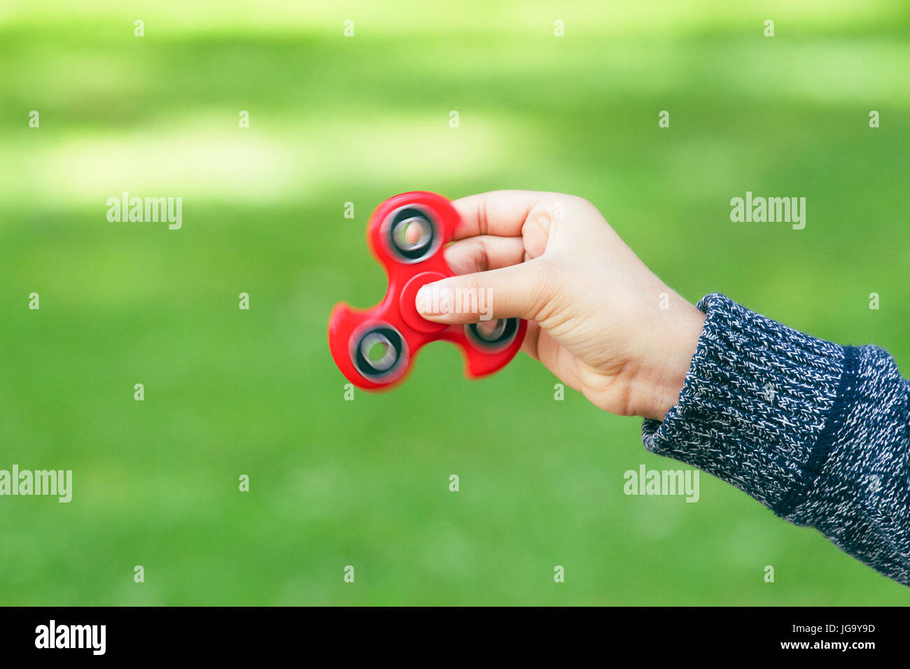 Red zappeln Spinner zappeln in Boy's Hand Stockfoto