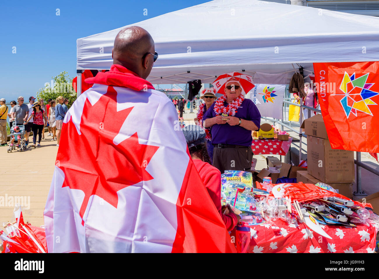 Mann mit kanadischer Flagge, Canada Day, Village of Steveston, Richmond, British Columbia, Kanada. Stockfoto