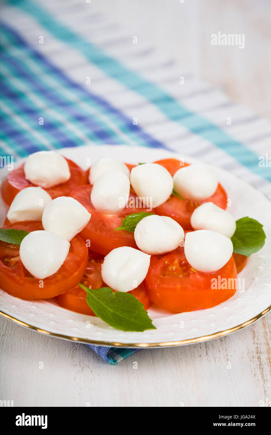Caprese Salat auf einem Holztisch. leckeren Salat mit Mozzarella, Tomaten und Basilikum. Stockfoto
