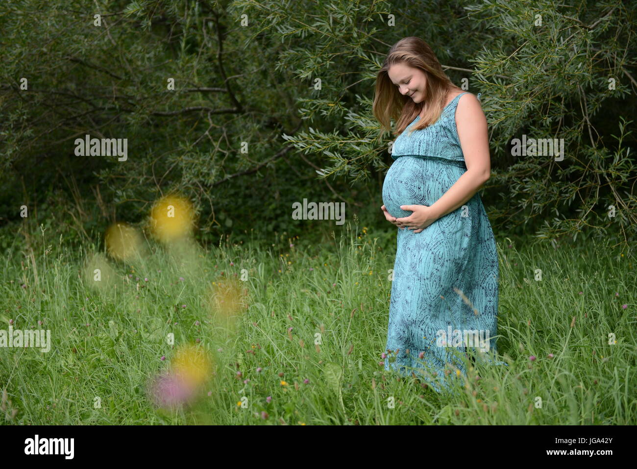 Schwangere junge Frau in einem park Stockfoto