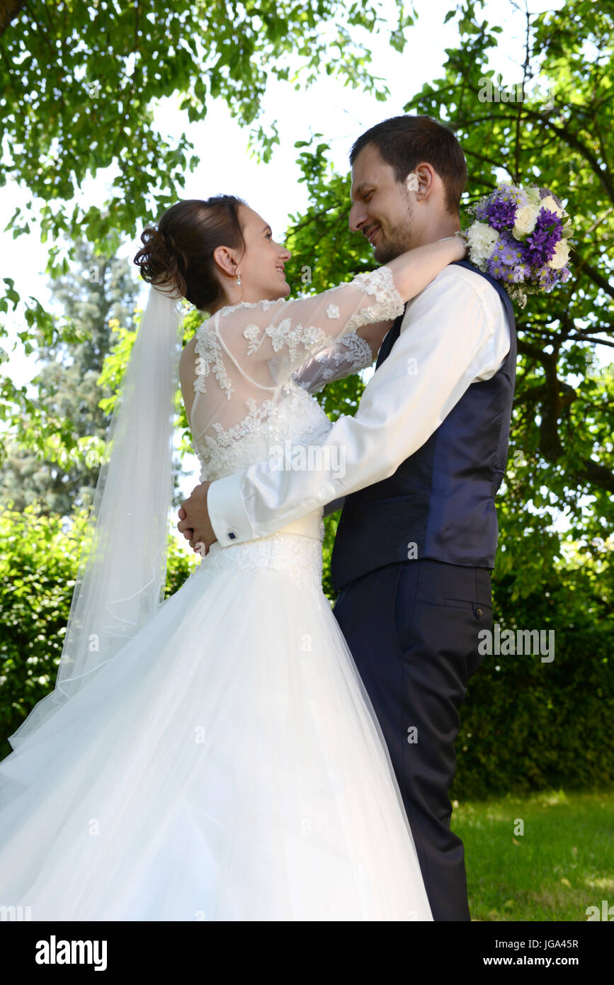 Glückliche Braut und Bräutigam einander umarmen Stockfoto