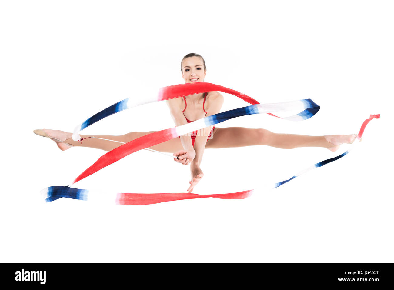 junge Frau rhythmischen Sportgymnastik mit Seil springen und Blick in die Kamera Stockfoto