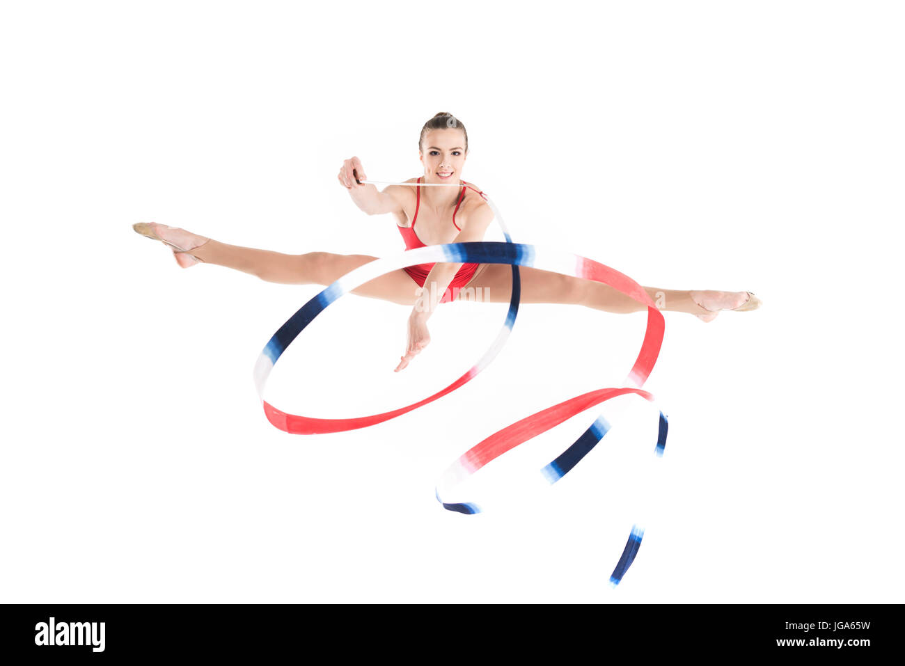 junge Frau rhythmischen Sportgymnastik mit bunten Seil springen und Blick in die Kamera Stockfoto
