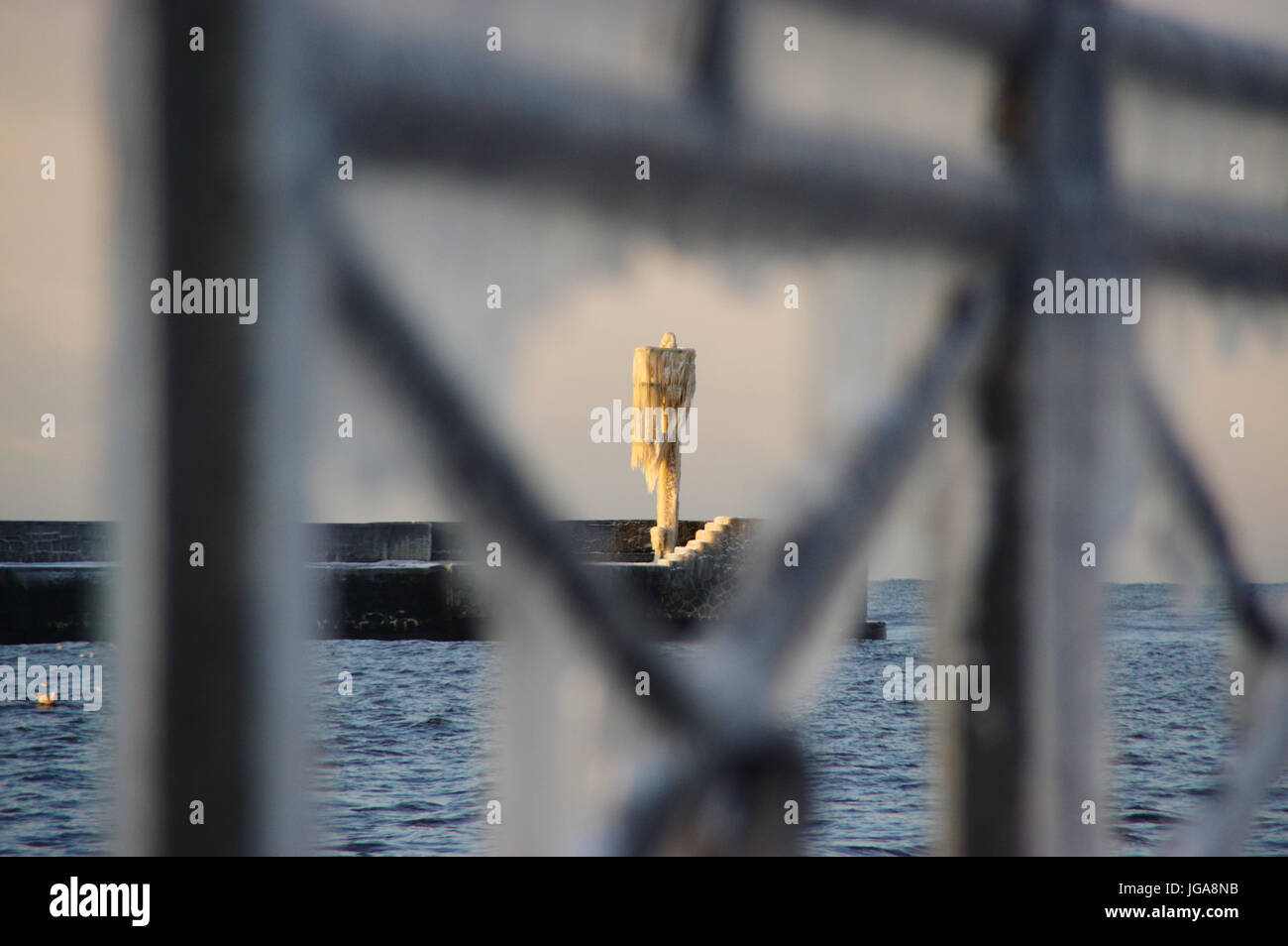 Die Skyline von Eiszapfen auf dem gefrorenen Hafen Lampe auf Pier. Winter am Meer. Stockfoto