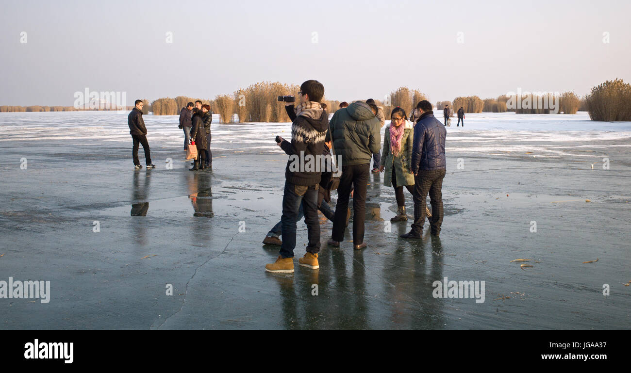 Gruppen von Menschen stehen und reden auf Oberfläche des zugefrorenen See, Shahu, Ningxia Stockfoto