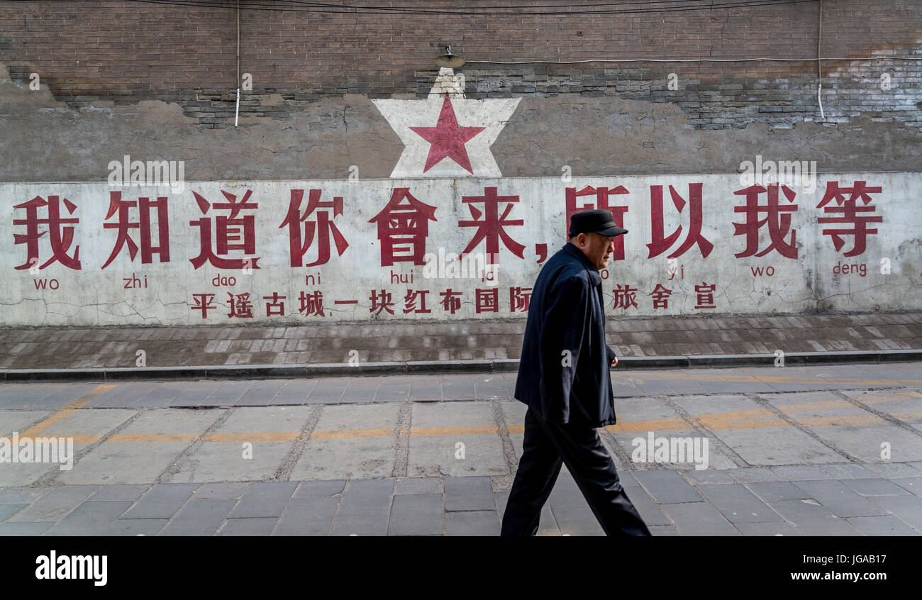 Mann vorbei maoistischen Slogan sagt "Ich weiß, Sie werden kommen, damit ich es kaum erwarten", Pingyao, Shanxi Provinz, China Stockfoto