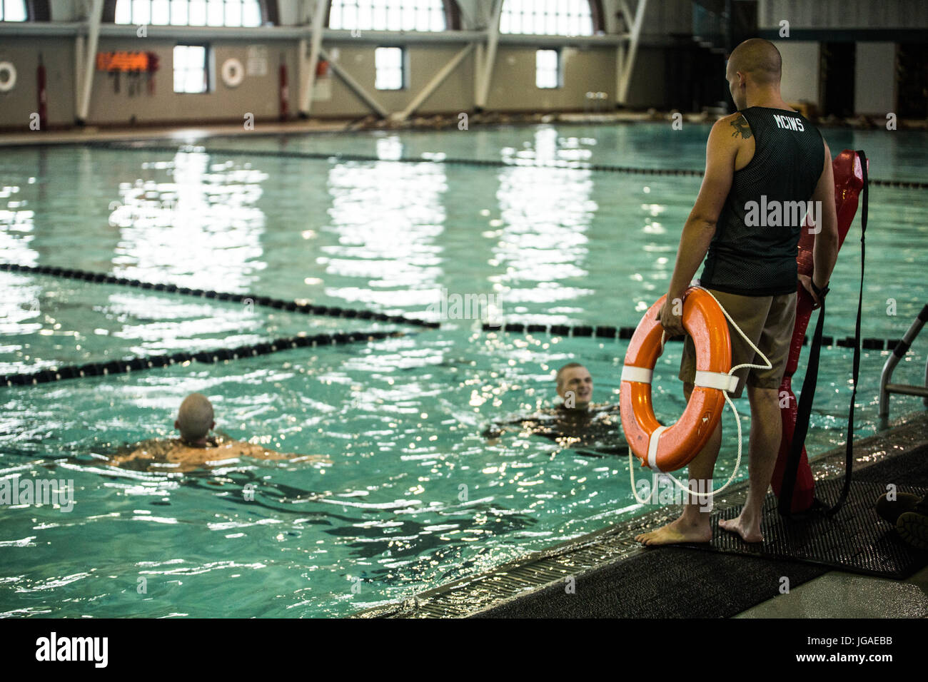 Ein Ausbilder Schwimmen mit Support Battalion, Uhren als Rekrut der Ostindien-Kompanie, 3. rekrutieren Training Bataillon, schwimmt während Schwimmen Qualifikation, 26. Juni 2017, auf Parris Island, SC Rekruten Wasser überleben müssen um zu absolvieren. Ostindien-Kompanie ist Diplom 25. August 2017 geplant. (Foto: Lance Cpl. Carlin Warren) Stockfoto