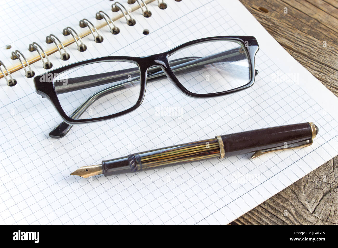 Füllfederhalter und Spiral-Notizbuch mit Brille Stockfoto