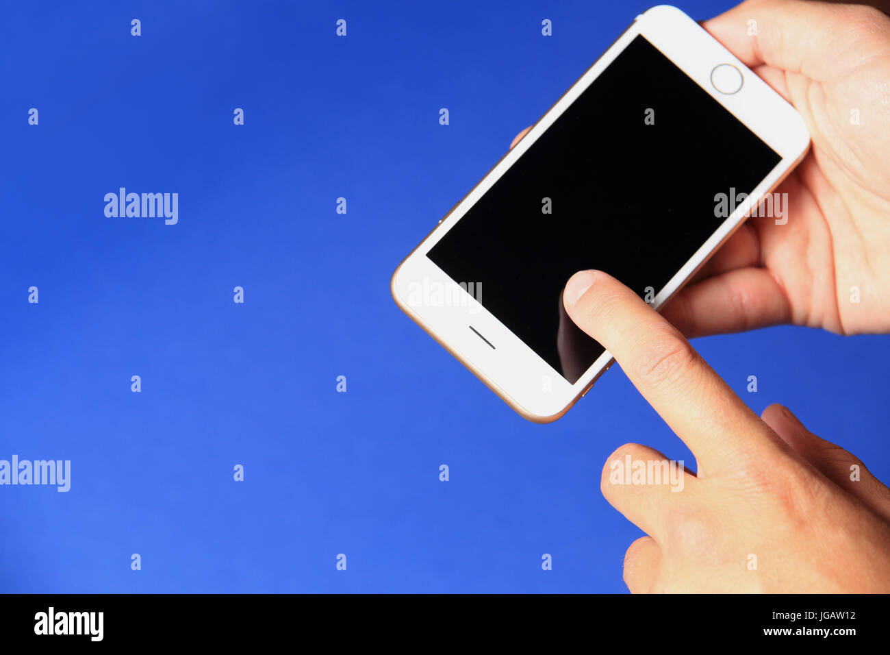 Neues Smartphone in der Hand auf blauem Hintergrund. Handy mit schwarzer Bildschirm-Nahaufnahme. Stockfoto