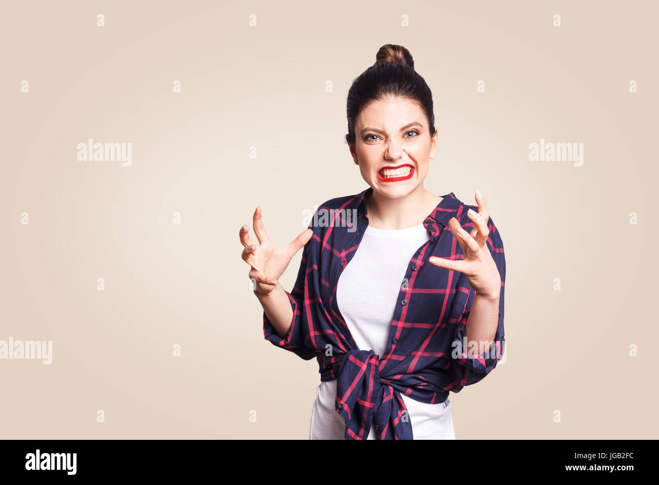 Porträt von gestresst und genervt lässig gestylt kaukasische Mädchen mit Haar Bun Händchenhalten in wahnsinnig wütend Geste, mit Ragea Nd Wut schreien Stockfoto