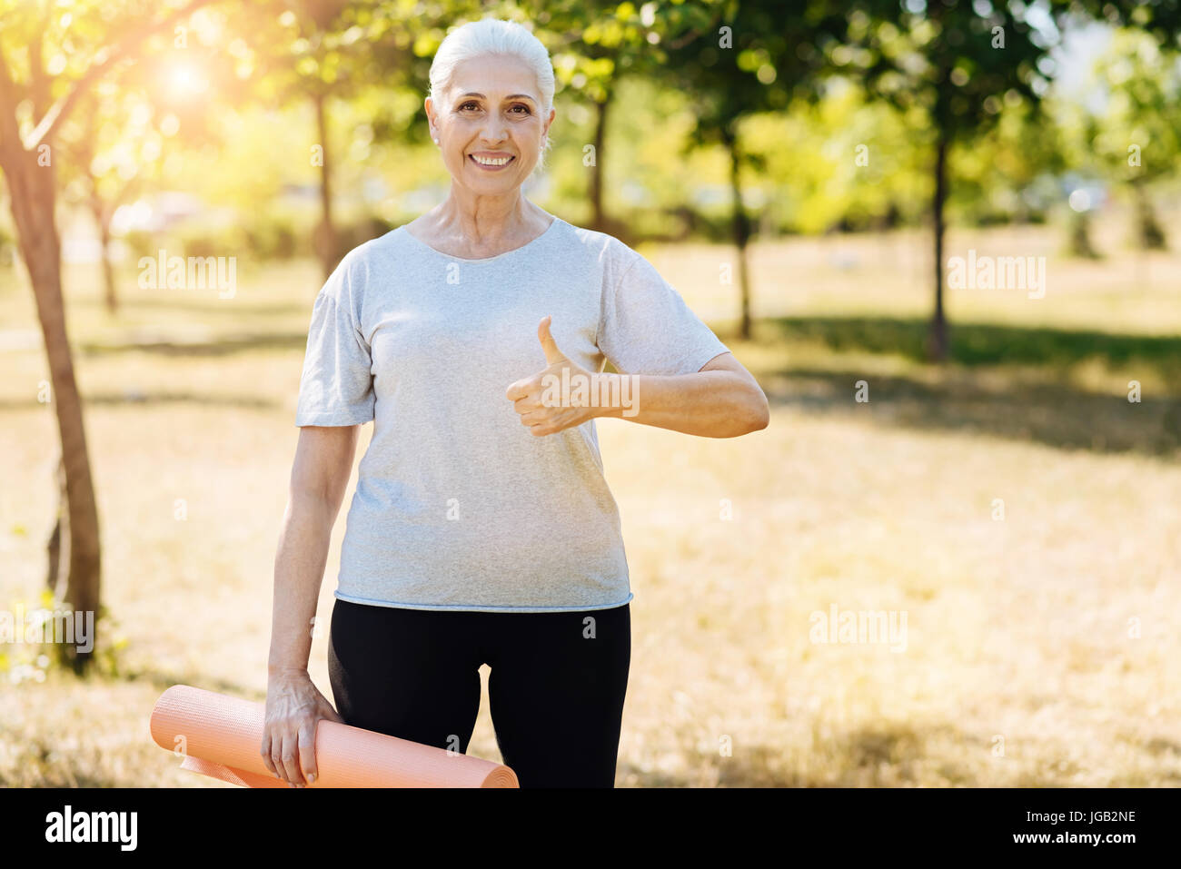 Fröhliche sportliche alte Frau blätterte bis Stockfoto