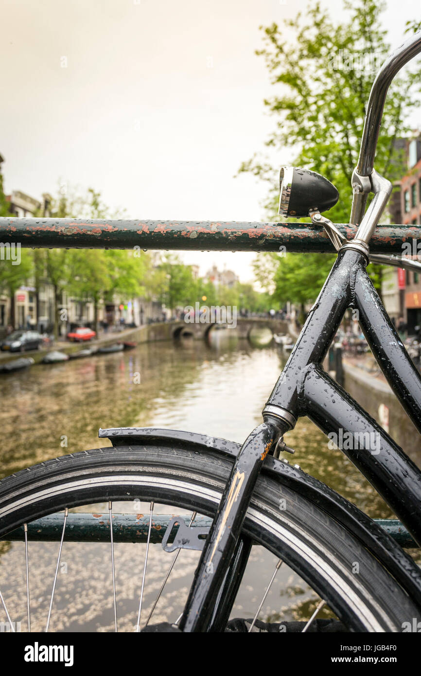 Schwarze Fahrrad über Kanal in Amsterdam, Niederlande Stockfoto