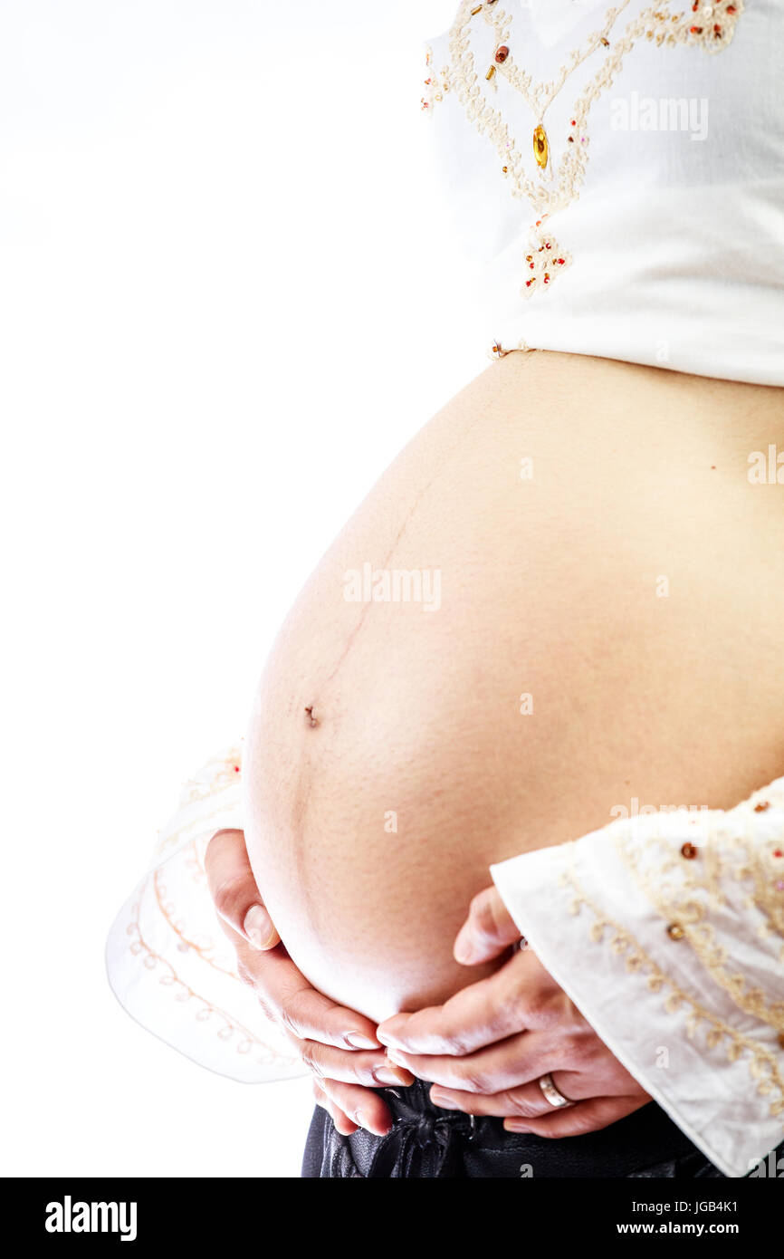 Schwangere Frau mit den Händen auf ihren grossen Bauch Stockfoto