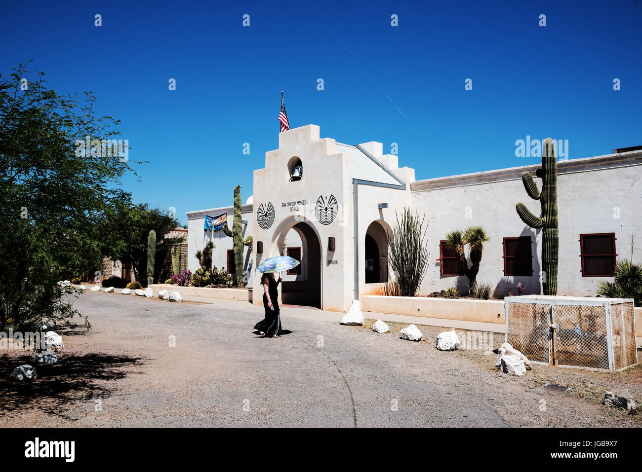 Touristen mit Regenschirm zu Fuß in der Nähe von Mission Schule, San Xavier Mission, Tucson, Arizona, USA Stockfoto