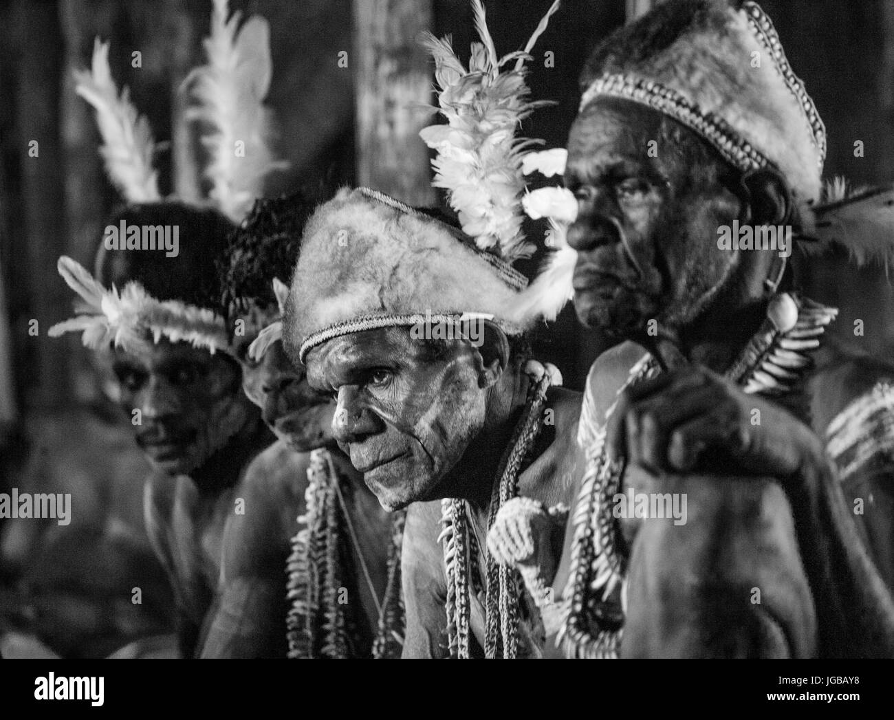 Indonesien, IRIAN JAYA, ASMAT Provinz, JOW Dorf - Juni 12: Krieger Asmat Stamm ist in traditionellen Kopfschmuck und Kriegsbemalung zu Hause sitzen. Stockfoto