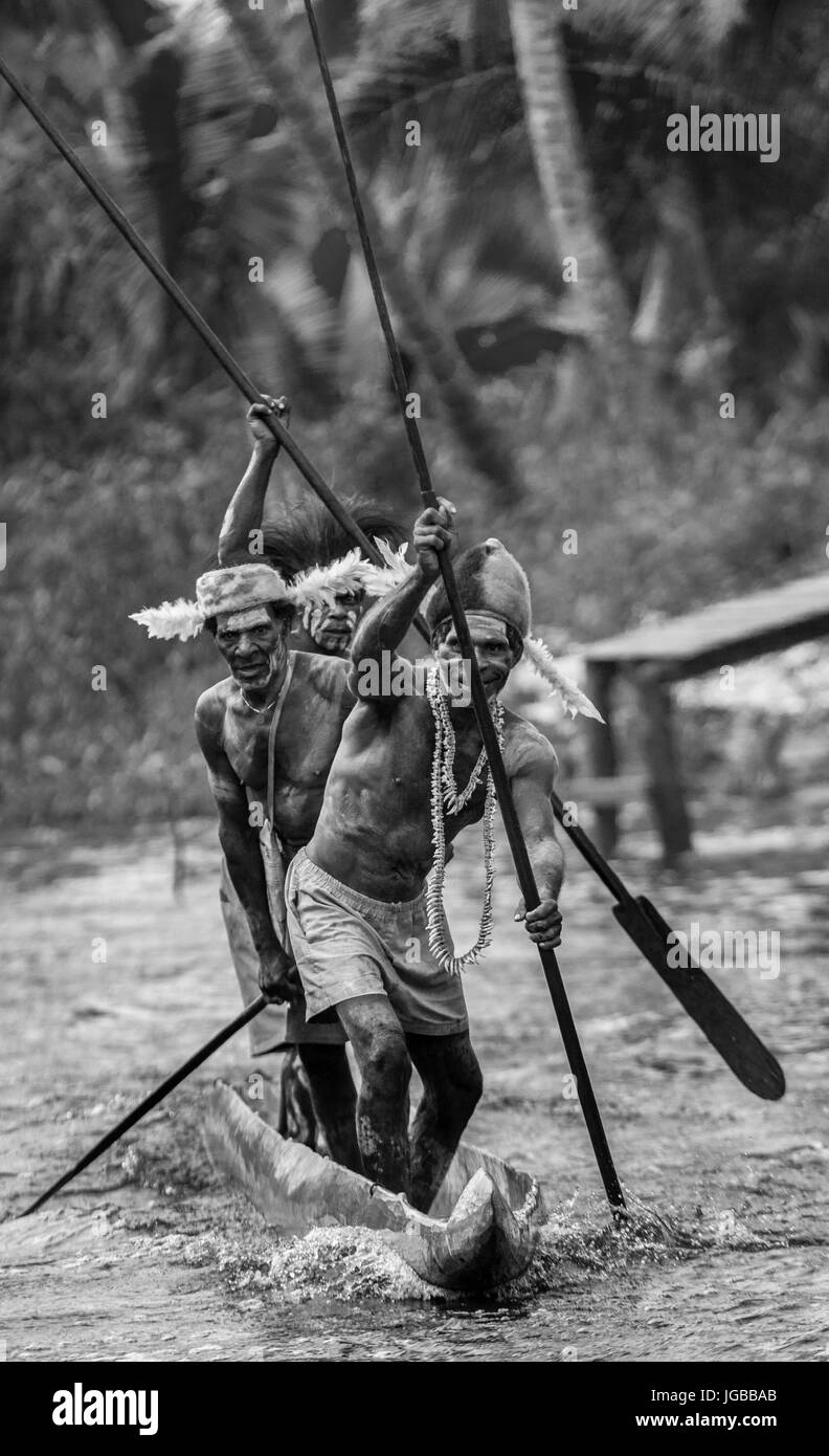 Indonesien, IRIAN JAYA, ASMAT Provinz, JOW Dorf - Juni 12: Krieger Asmat Stamm sind traditionelle Kanu verwenden. Stockfoto