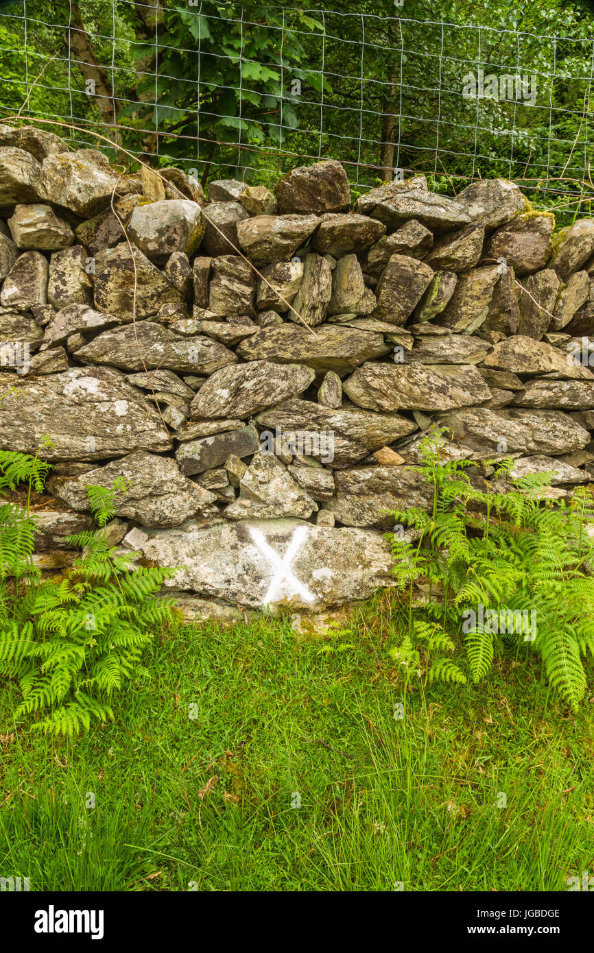 Nach einem Pulver Öl Explosion 1869 Rad und Kabelbaum gefunden durch diese Mauer markiert X diese Cwm y Glo, Llanberis, Wales, Vereinigtes Königreich. Stockfoto