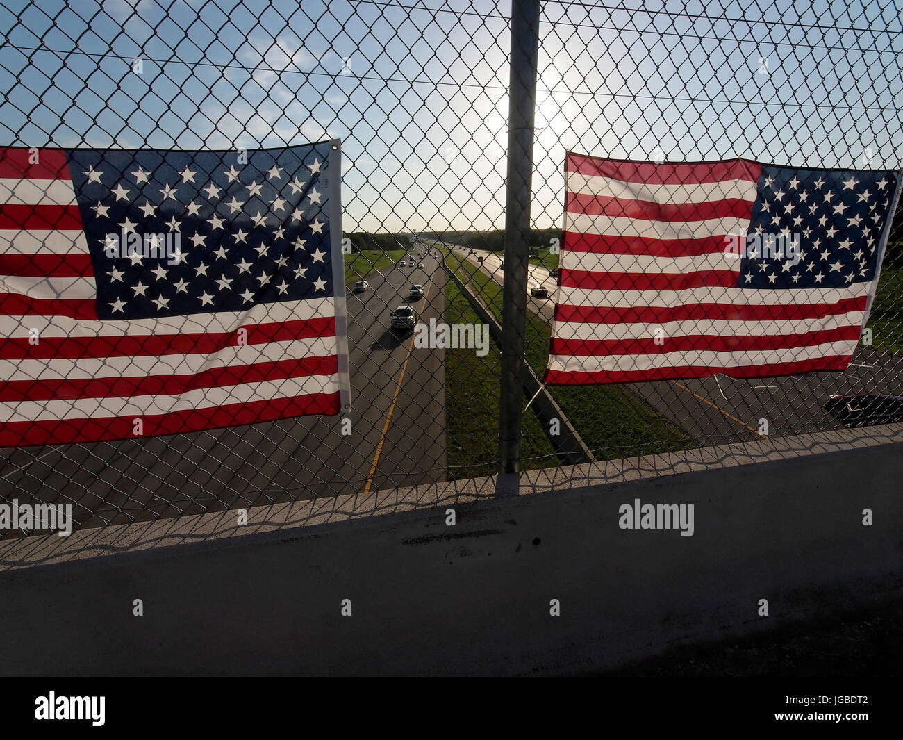 Zur Feier des vierten Juli Urlaub Studenten reagieren auf einen Lehrer Vorschlag die amerikanische Flagge auf einem Zaun mit Blick auf einen großen Highway zwischen Dallas und Fort Worth, Texas zu hängen. Treiber nahm Fotos mit Ihrem Mobiltelefon und die Polizei machte sie die Flags entfernen Stockfoto