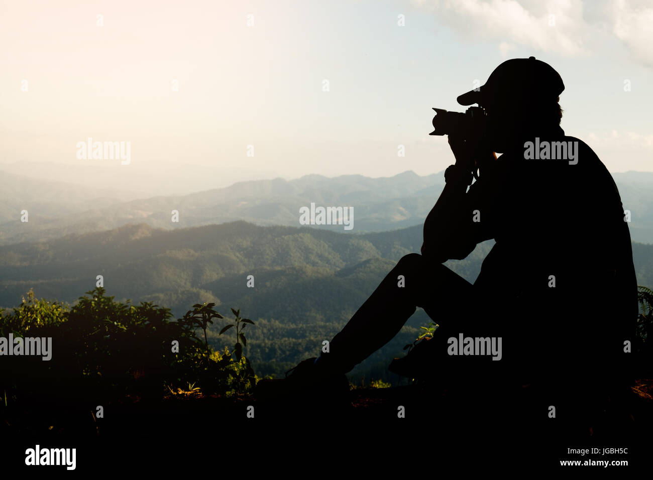 Silhouette von einem jungen, die gerne reisen und Fotografen, die Bilder von der schönen Momente während der Sonnenuntergang, Sonnenaufgang und Berg. Stockfoto