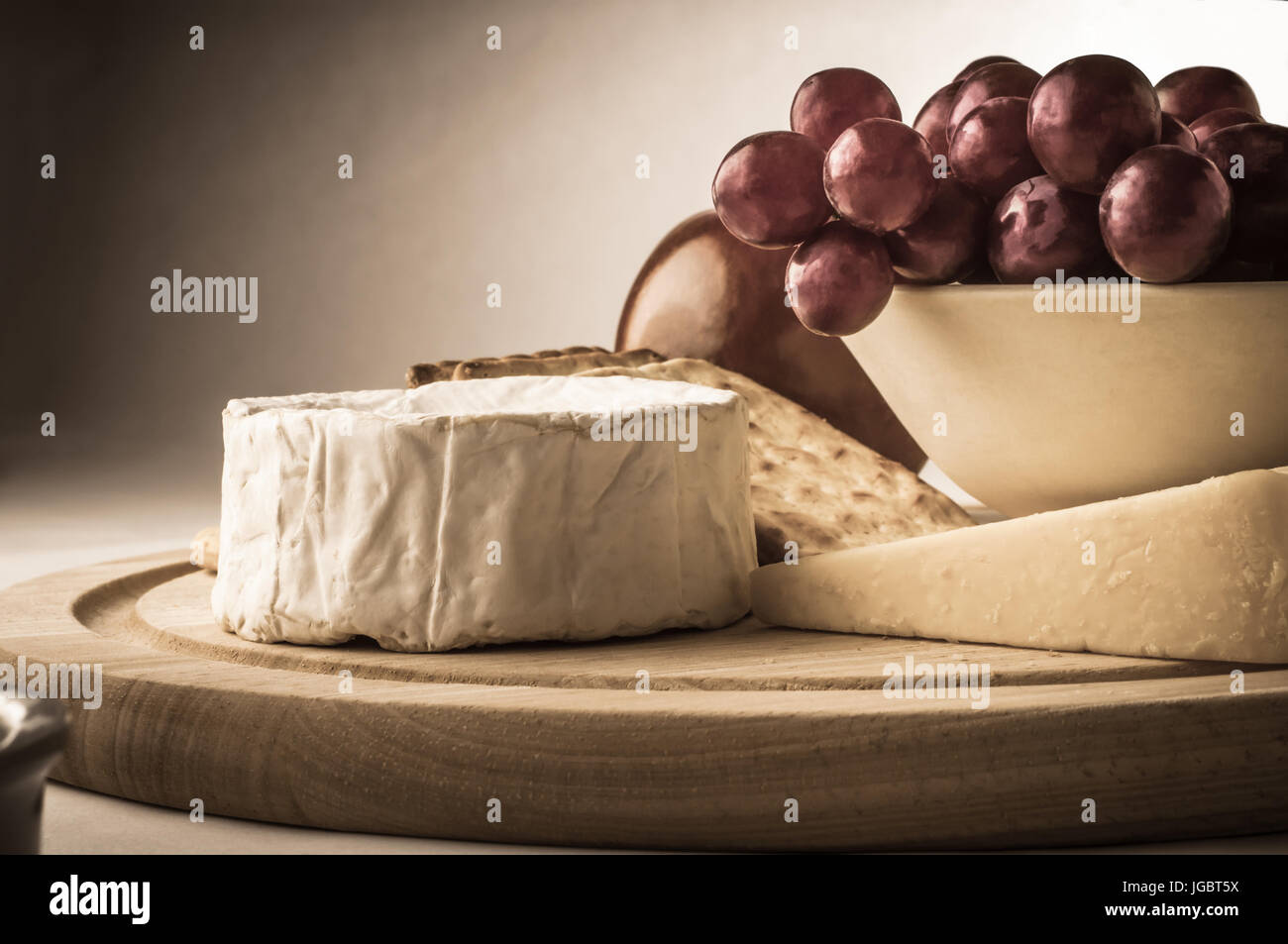 Malerische Foto aus einer Stillleben Anordnung von Käse, Cracker, Traube Schüssel und Apfel.  In einem Alter, Vintage-Stil mit leicht Desatur verarbeitet Stockfoto