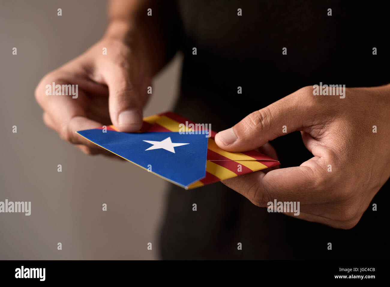 Nahaufnahme eines jungen Mannes mit einem Umschlag mit der Estelada, die katalanische Flagge pro-Unabhängigkeit, Darstellung der katalanischen Unabhängigkeitsreferendum gemustert Stockfoto