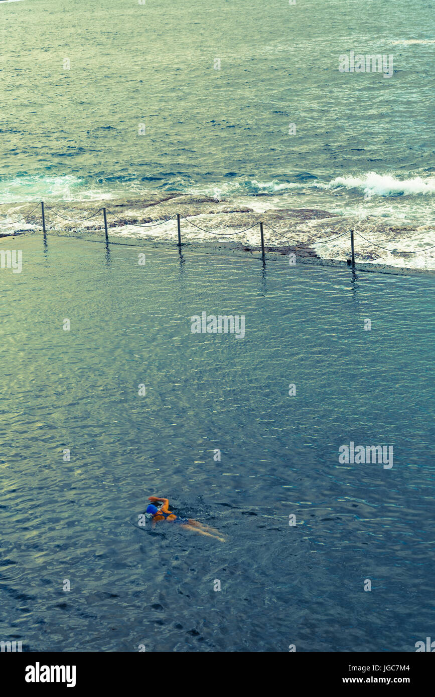 Person schwimmen in Wylies Baths, ein Gezeitenbecken in der Nähe von Coogee Beach, Eastern Suburbs, Sydney, Australien Stockfoto