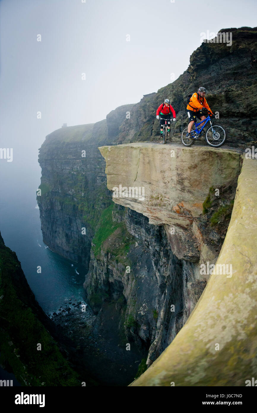 Professionelle Mountainbiker Hans Rey und Steve Peat reiten die Cliffs of Moher Stockfoto
