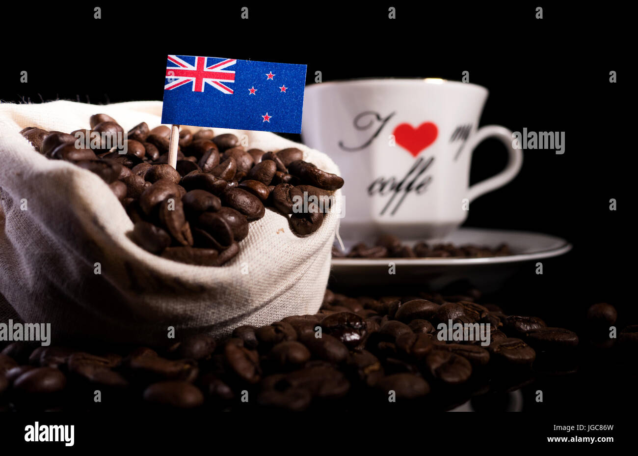 Neuseeland Fahne in einer Tasche mit Kaffeebohnen auf schwarzem Hintergrund isoliert Stockfoto