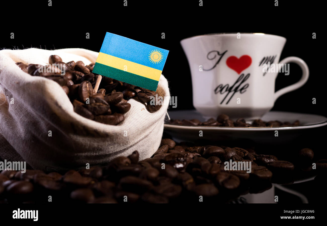 Ruanda-Flag in einer Tasche mit Kaffeebohnen auf schwarzem Hintergrund isoliert Stockfoto