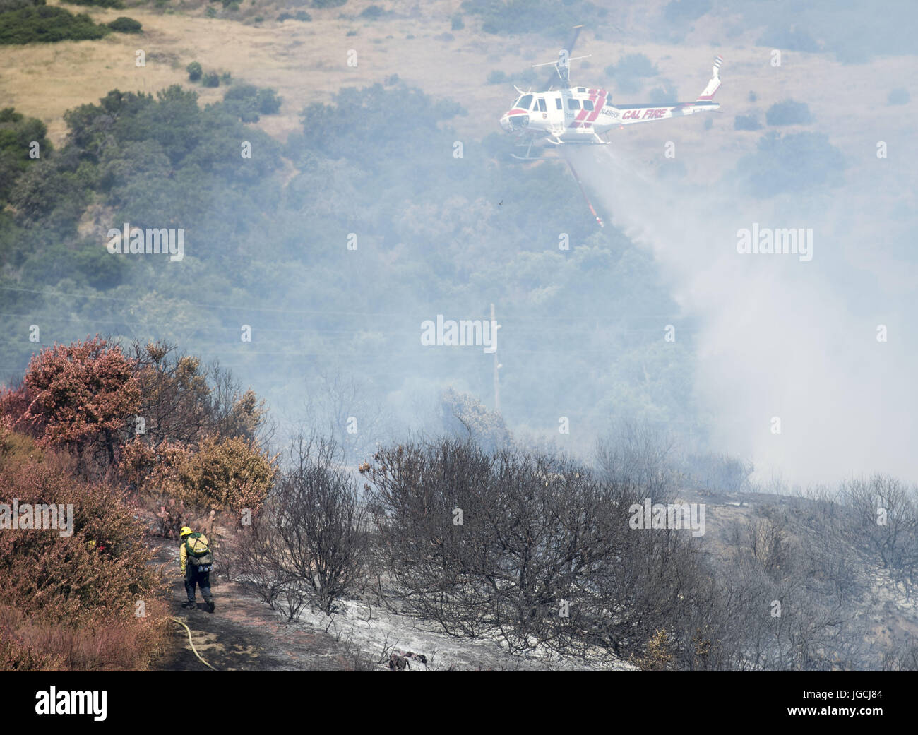 San Clemente/Talega, Kalifornien, USA. 5. Juli 2017. Ein OCFA Hubschrauber macht eine Wasser Tropfen entlang der Feuerlinie. Die Orange County Fire Authority reagierte auf einem 25 Hektar großen Vegetation Feuer am Mittwochnachmittag am Ende der Avenida Pico in San Clemente. Die OCFA wurde von Cal Fire sowie Feuerwehrleute vom Camp Pendleton unterstützt. Rund 100 Feuerwehrleute griffen die Flammen in hügeligem Gelände mit den Adjutanten von zwei Cal Feuer festen Tragflächen sowie Hubschrauber aus Cal Fire und dem OCFA. Bildnachweis: ZUMA Press, Inc./Alamy Live-Nachrichten Stockfoto