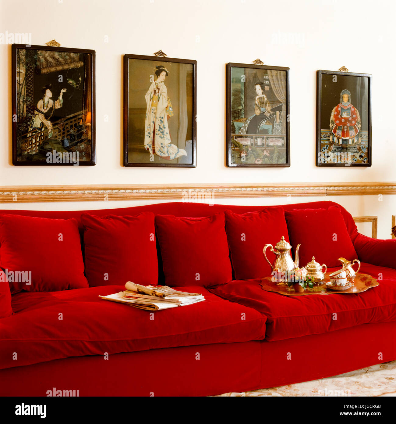 Rotes Sofa mit orientalischen Gemälden Stockfoto