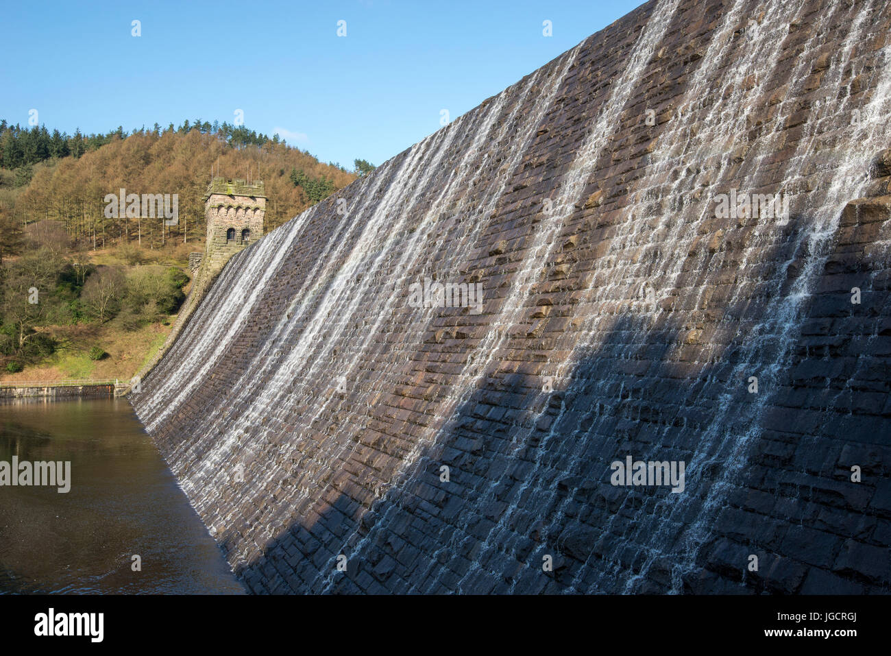 Wasser fließt über den großen Stein Damm des Derwent Stausees in der Peak District National Park, Derbyshire, England. Stockfoto