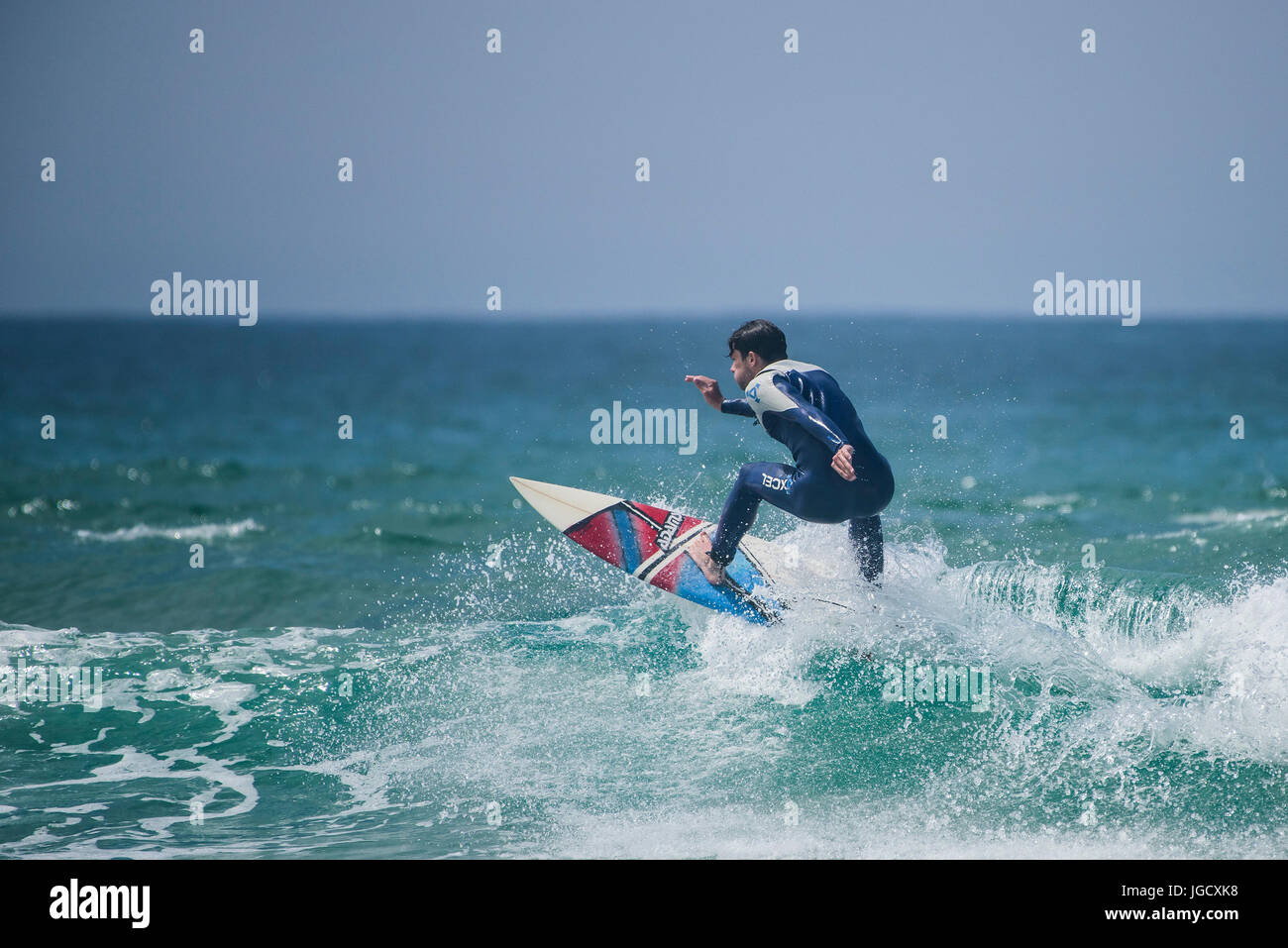 Surfen-UK; Spektakuläre Action als Surfer reitet eine Welle am Fistral in Newquay, Cornwall. Stockfoto