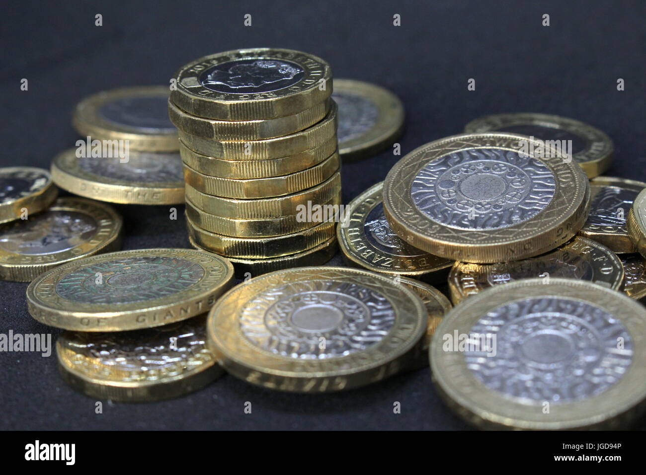 Ein Haufen von britischen Pfund Sterling Münzen - neu Pfund Münzen und zwei-Pfund-Münzen vor einem dunklen Hintergrund Stockfoto