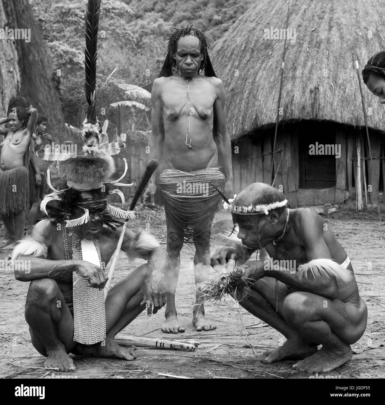 DANI-Dorf, WAMENA, IRIAN JAYA, Neuguinea, Indonesien – 25. Juli 2009: Männer Dani Stamm Feuer zu schüren. Stockfoto