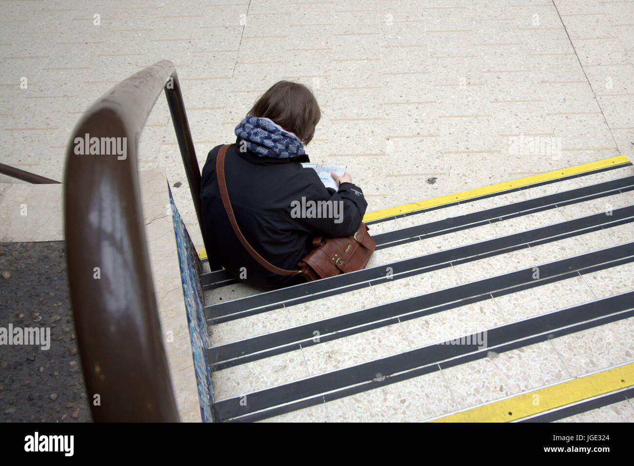 Pendler Passagier Tourist sitzt auf einem Schritt angesehen von hinten Stockfoto