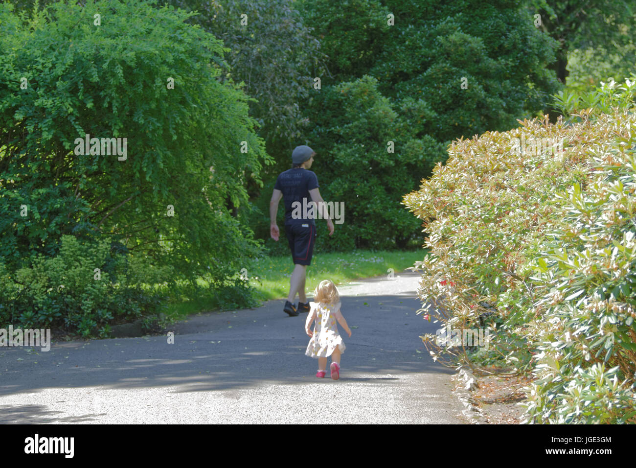 Vater und Tochter Kleinkind Baby spazieren im Park spiegeln einander Weg Stockfoto