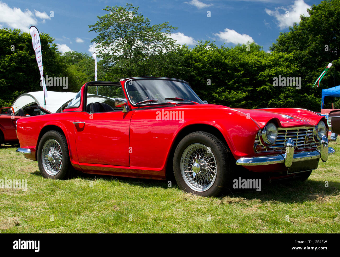 Seitenansicht eines leuchtend roten Triumph-Sportwagens auf der Messe bei einem Oldtimerevent in Wales, Großbritannien Stockfoto