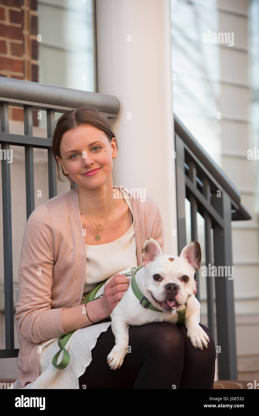 Porträt des kaukasischen Frau sitzt am Treppenabsatz mit Hund Stockfoto