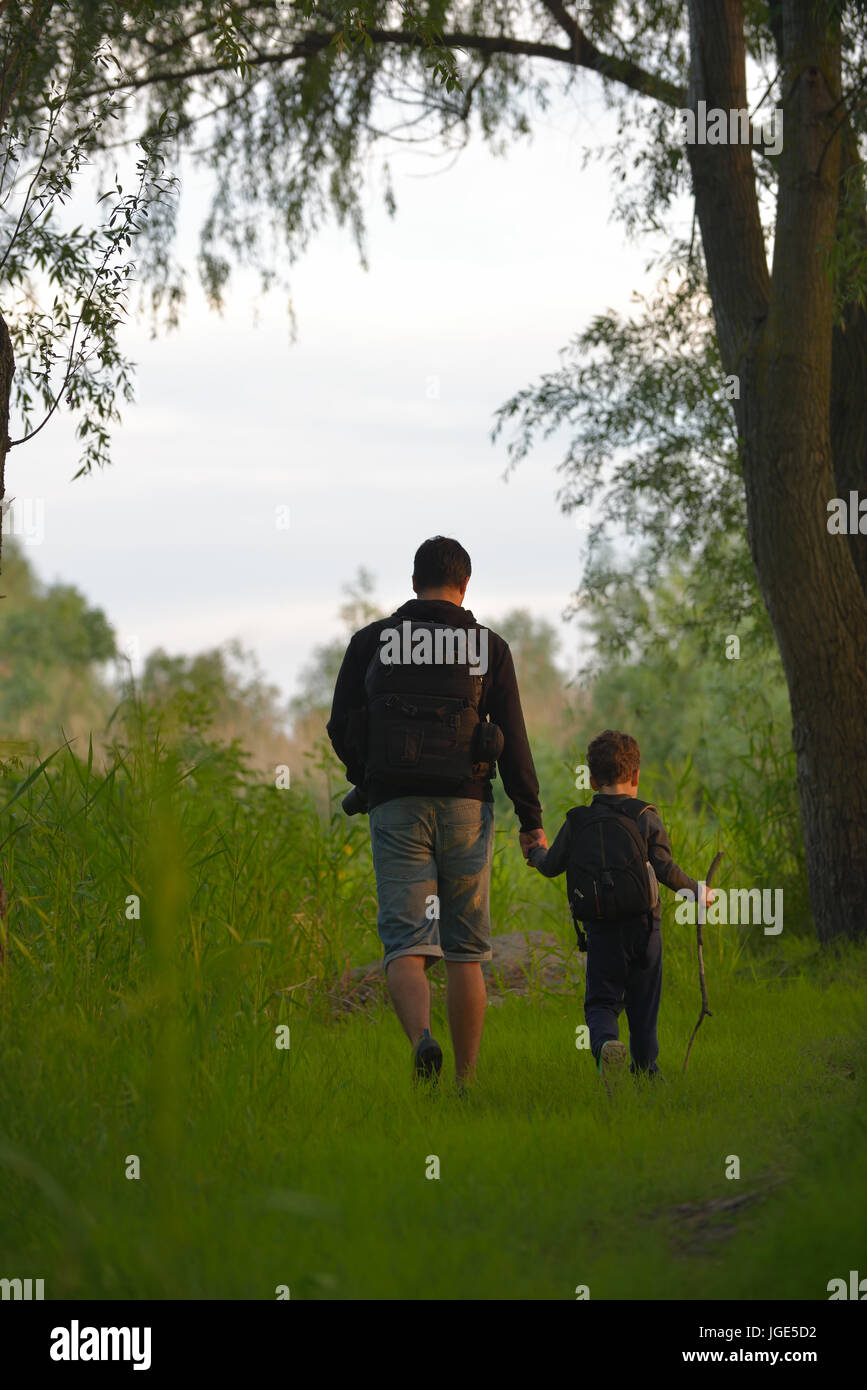 Vater und Sohn zu Fuß in den Wald bei Sonnenuntergang Stockfoto