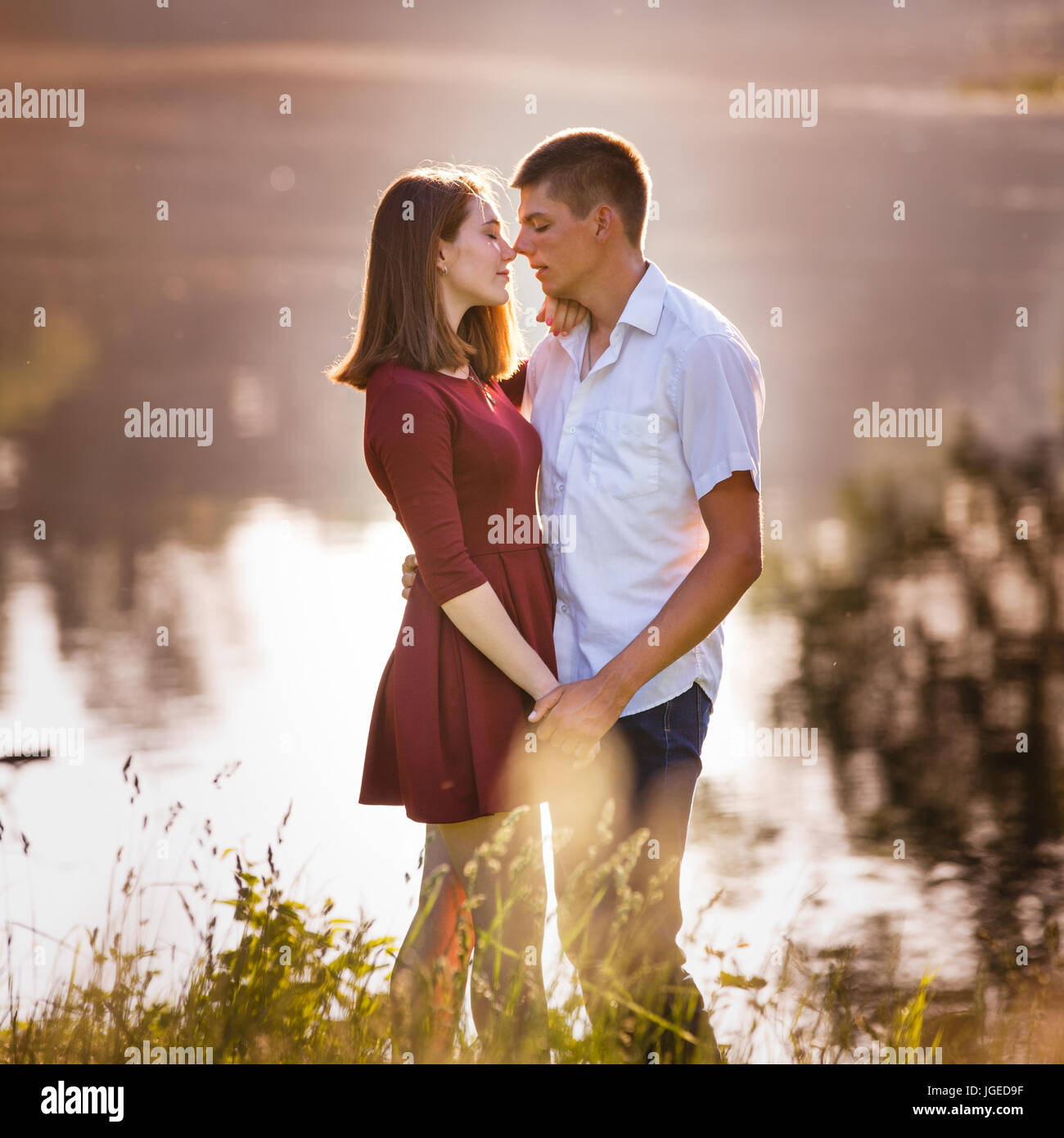 Porträt eines schönen jungen Paares in der Liebe stehen und küssen in der Nähe des Flusses. Stockfoto