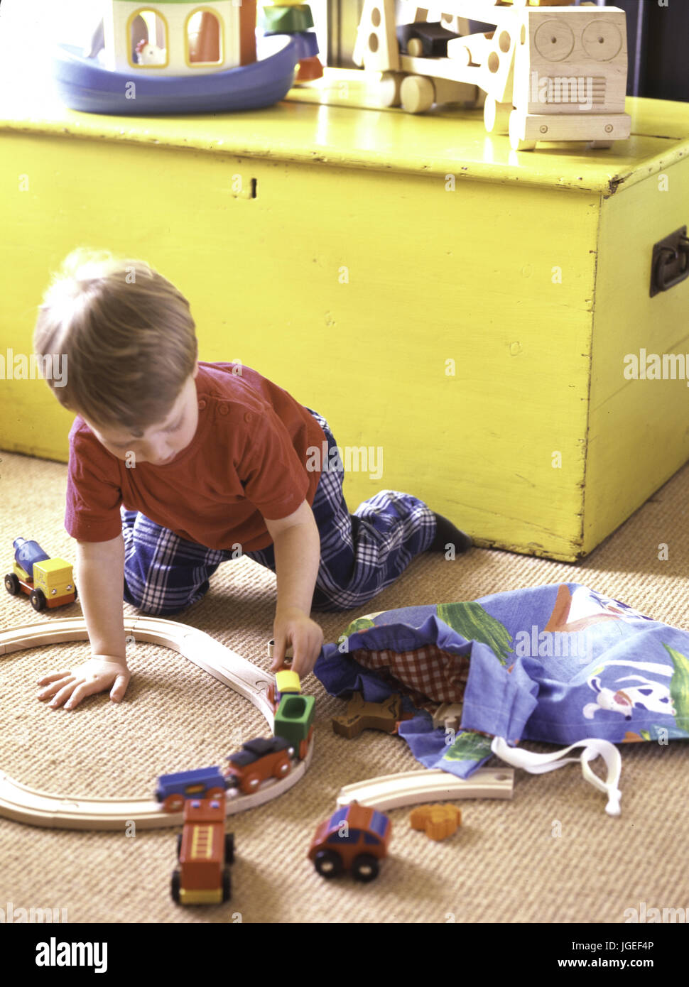 Kleiner Junge spielt mit Holzeisenbahn set Stockfoto