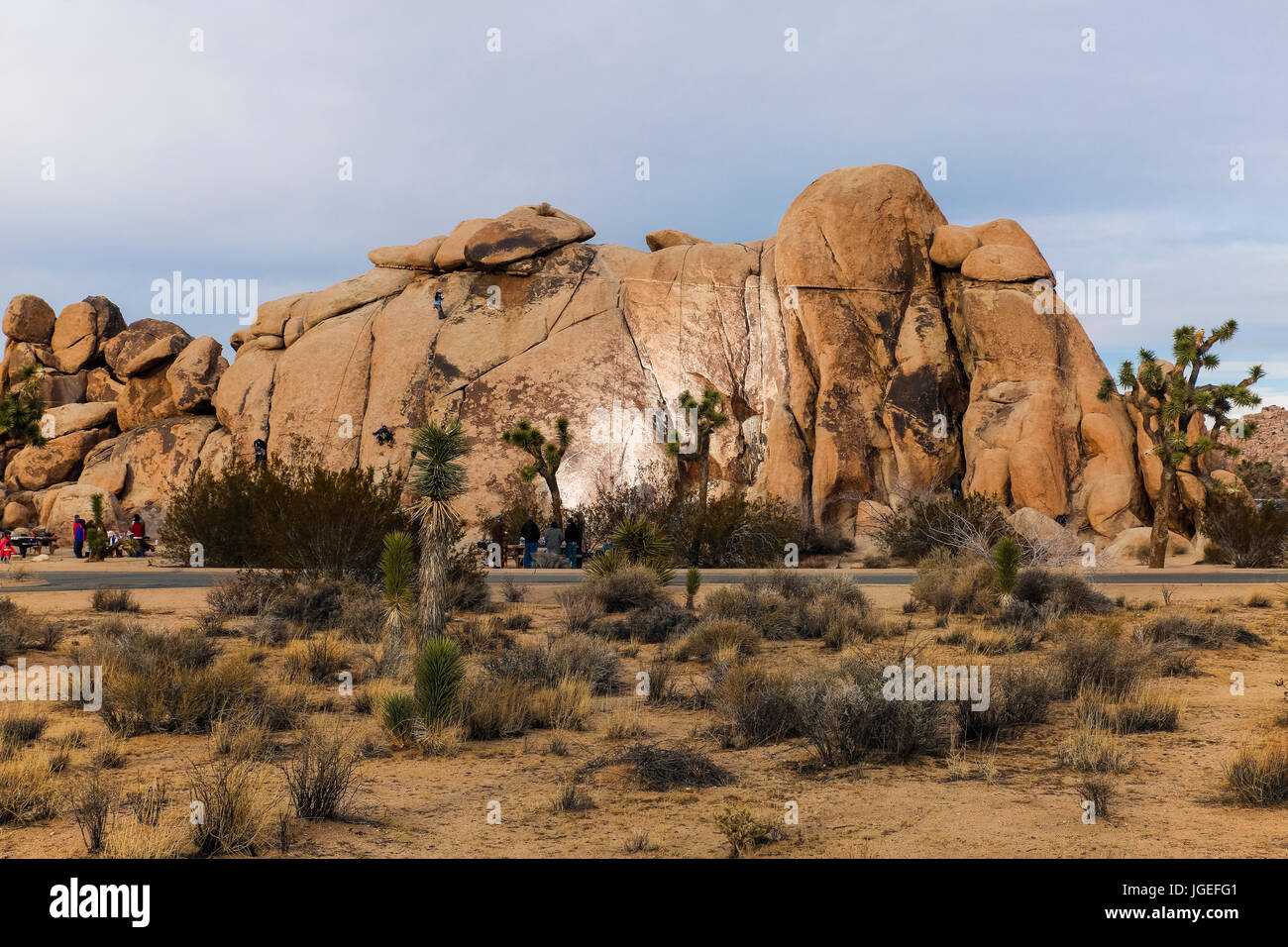 Freunde stehen um in die Wüste Suche an einem Felsen klettern Herausforderung Stockfoto