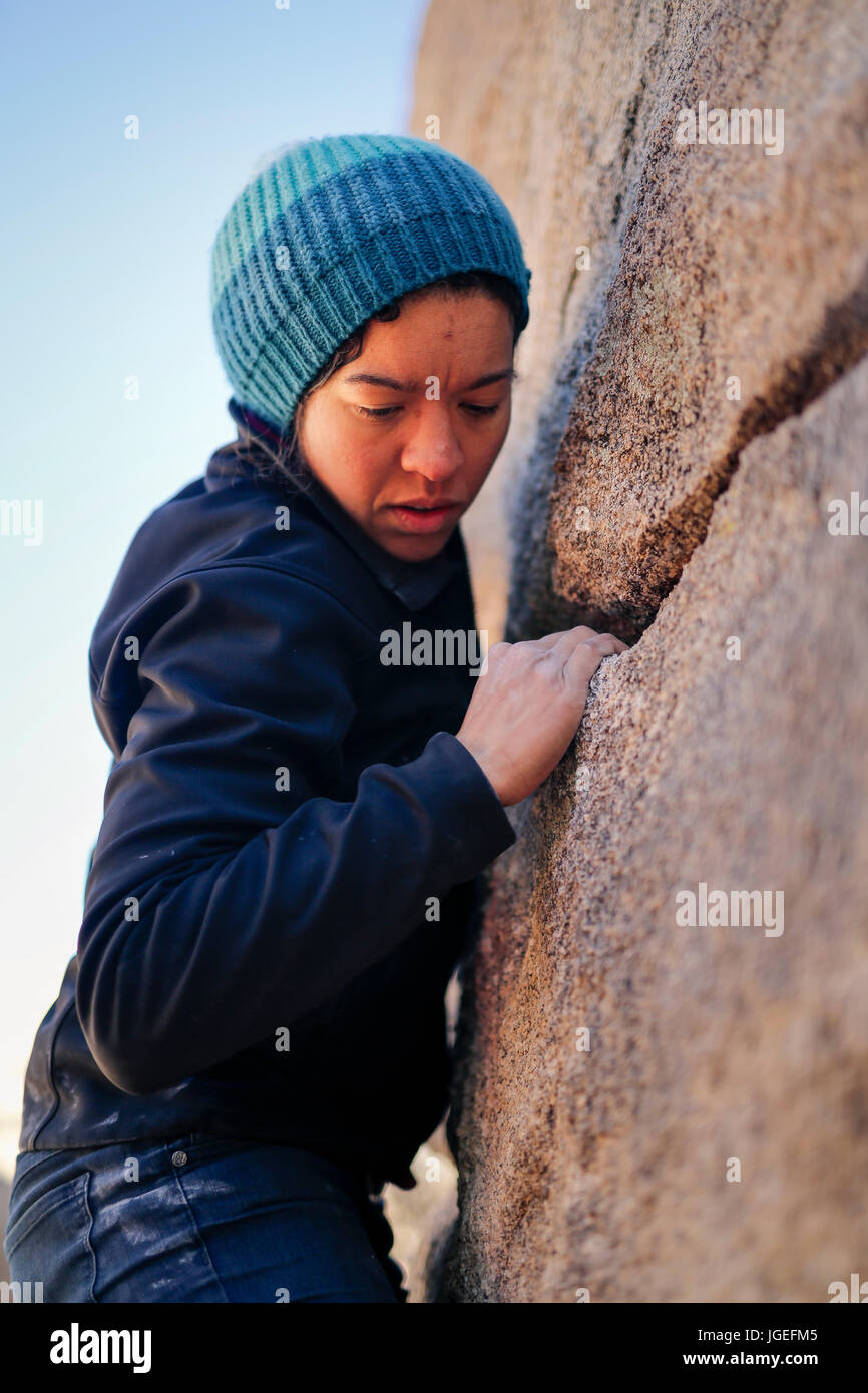 Junge Mischlinge Frau gekleidet in kaltem Wetter Kleidung Felsen klettert in der Wüste Stockfoto